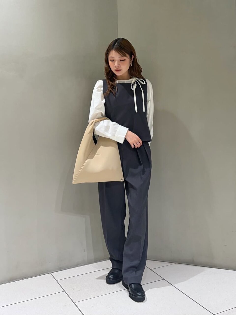 スクエアネックベストとテーパードパンツを着た女性