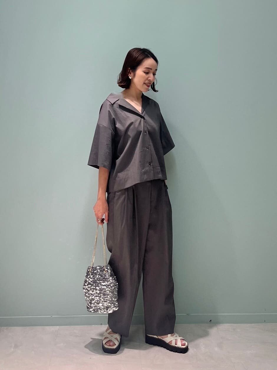 オープンカラーシャツとテーパードパンツを着た女性