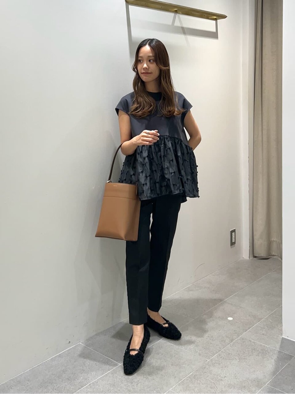 フレンチスリーブブラウスとテーパードパンツを着た女性