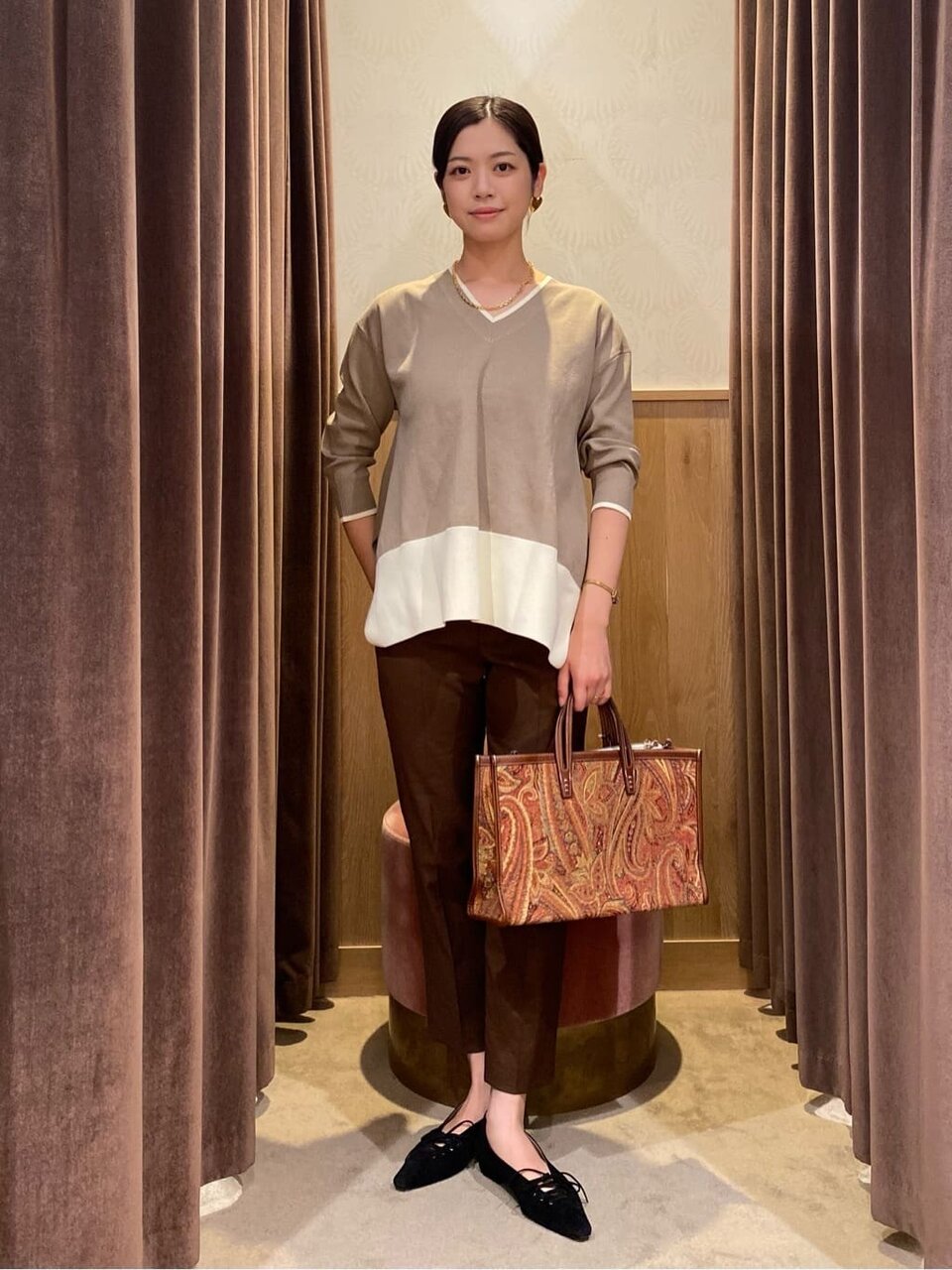 Vネックニットテーパードパンツを着た女性