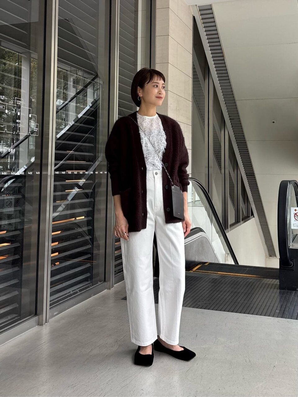 ニットカーディガンテーパードパンツを着た女性