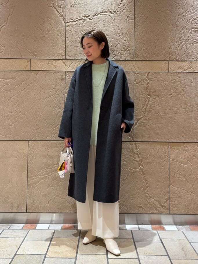 チェスターコートとワイドパンツを着た女性