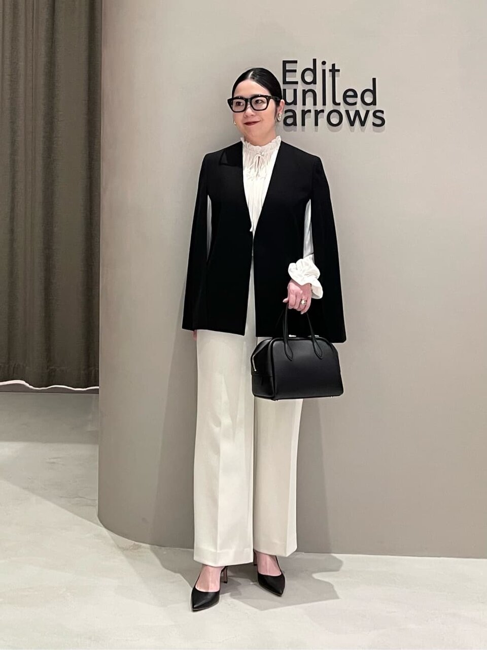 ノーカラージャケットとワイドパンツを着た女性