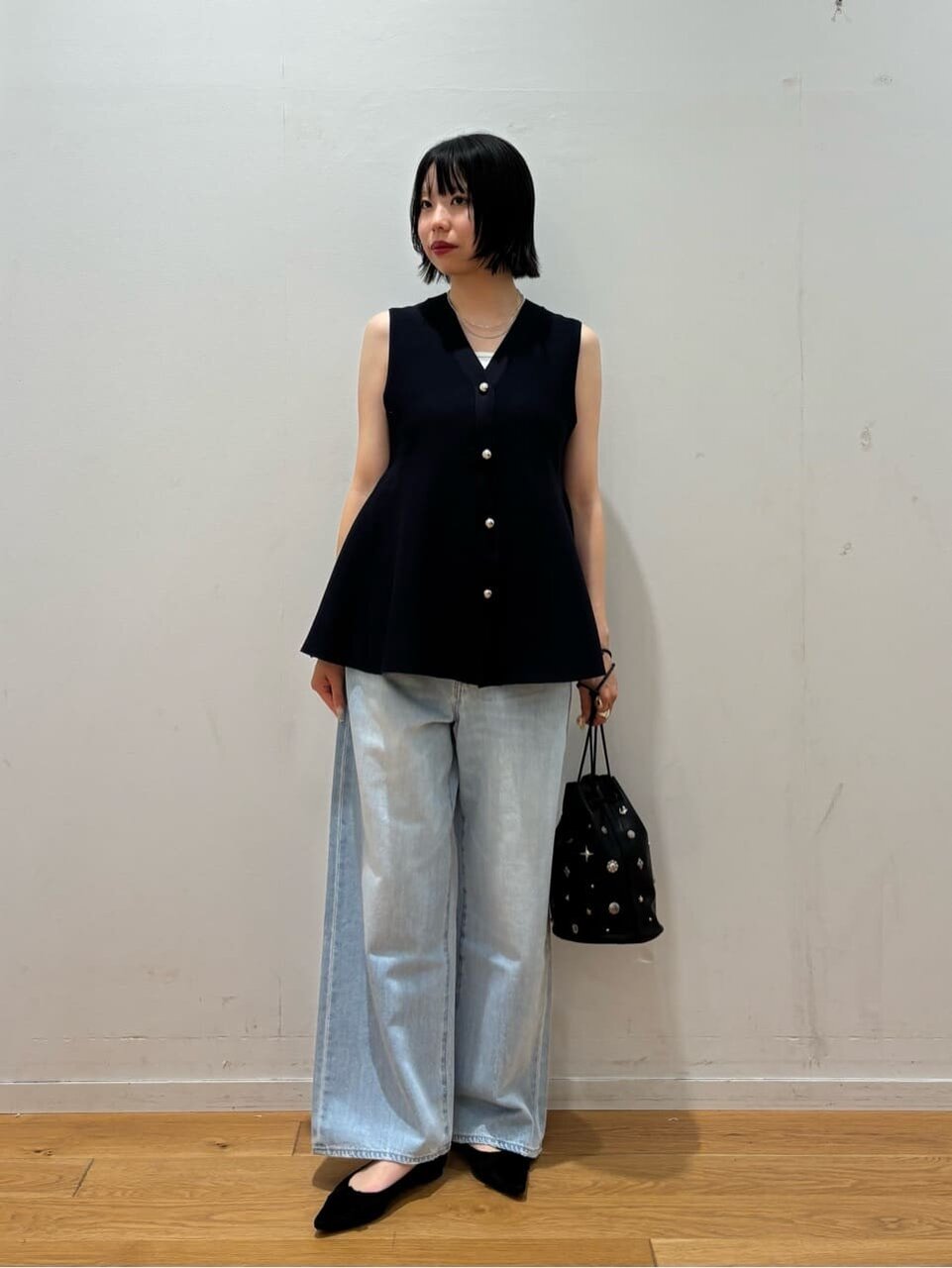 ニットジレとワイドパンツを着た女性