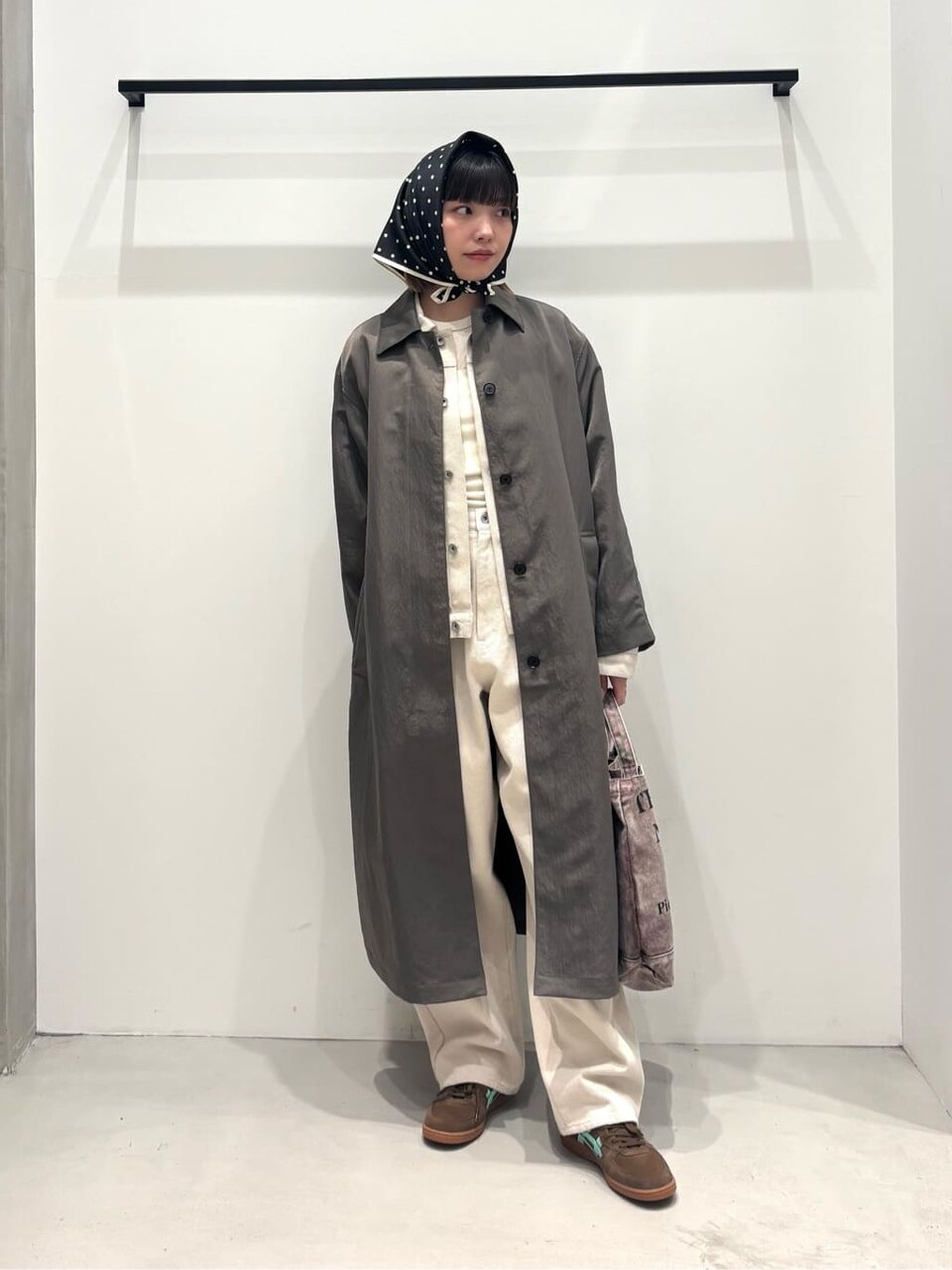 ステンカラーコートとワイドパンツを着た女性