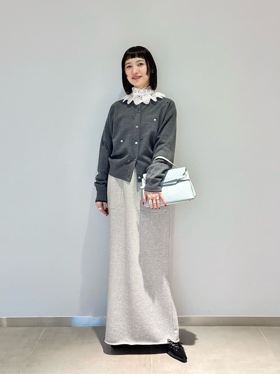 カーディガンとロングスカートを着た女性