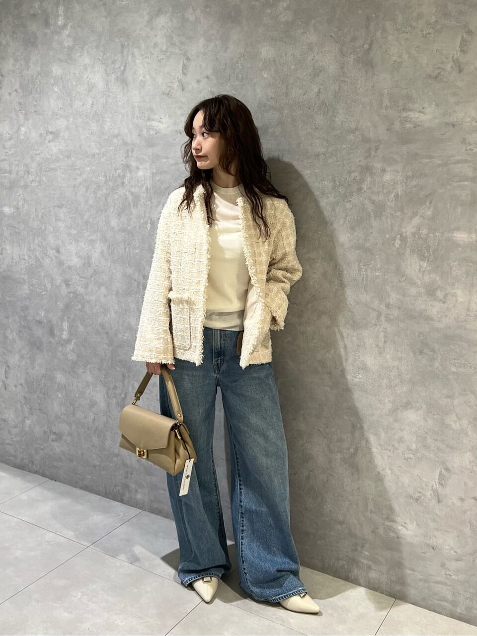 ツイードジャケットとデニムを着た女性