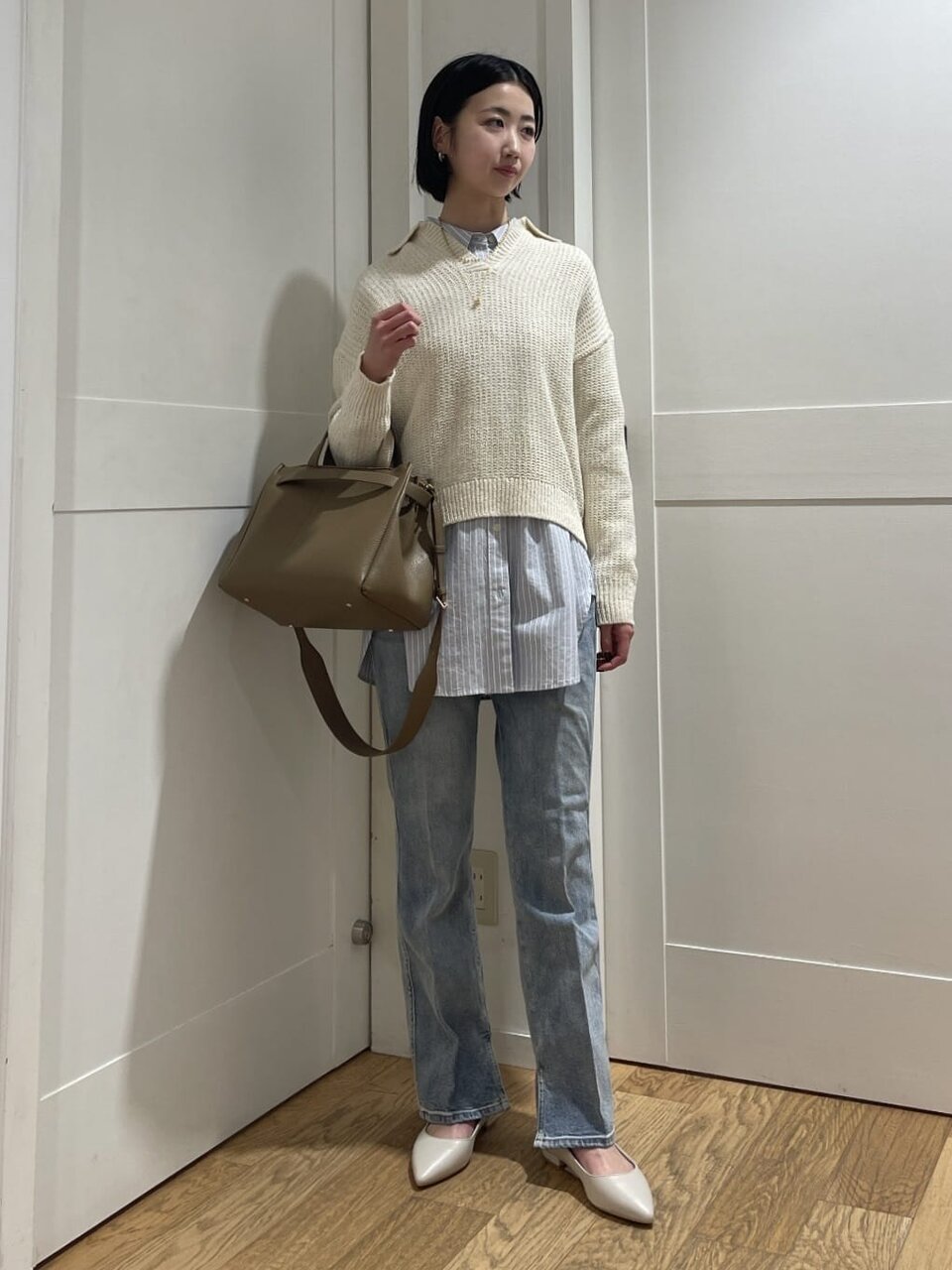 フレアデニムパンツをはいた女性