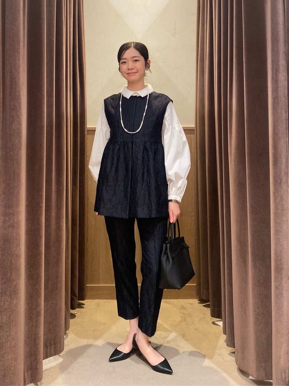 ペプラムベストを着た女性