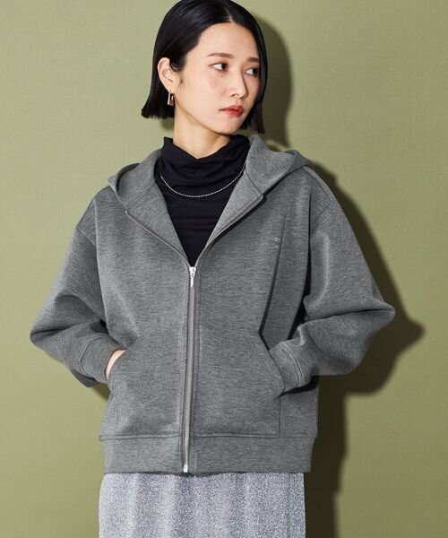 パーカーを着ていてネックレスとピアスをつけている女性