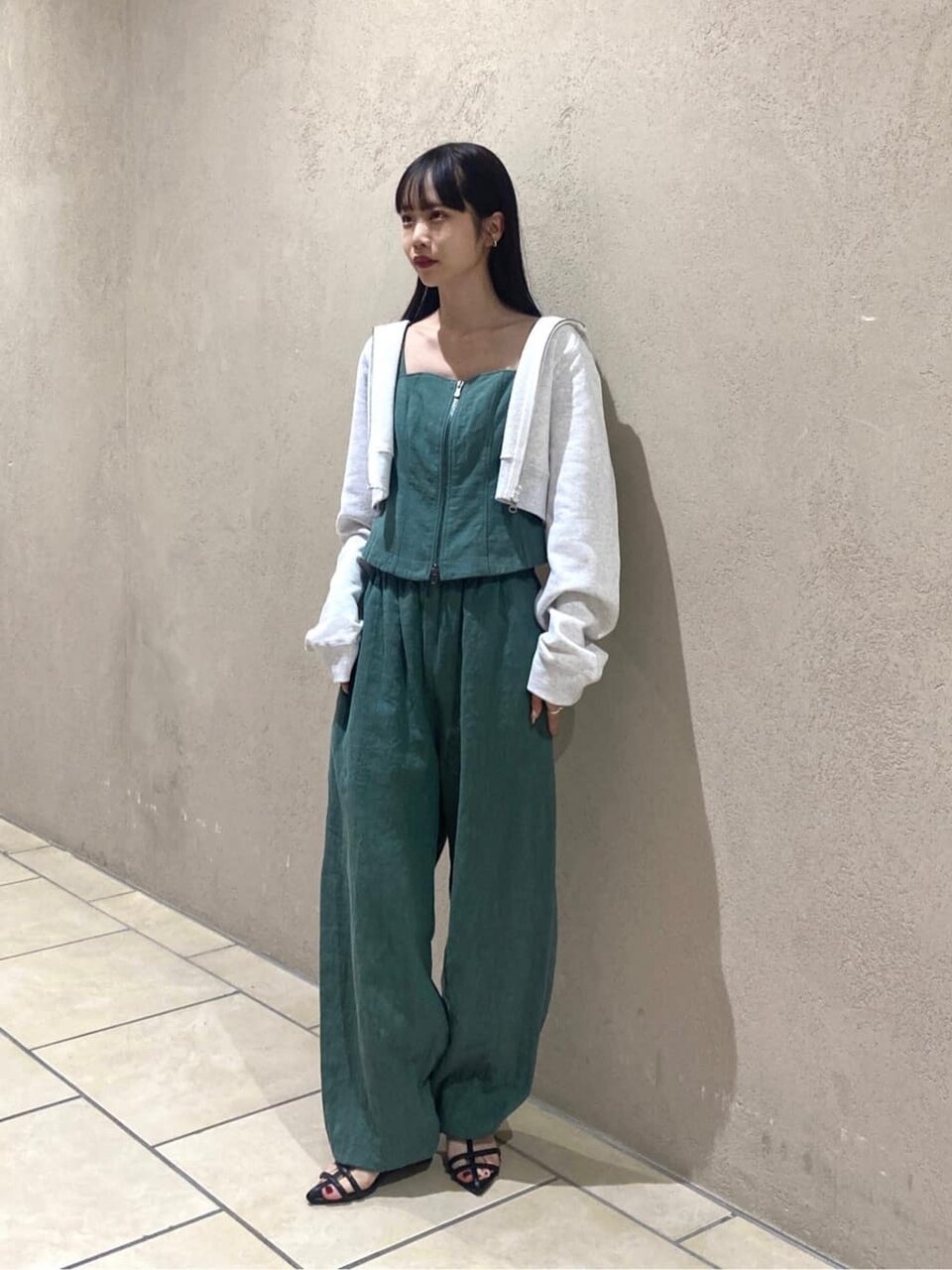 グリーンのセットアップとホワイトパーカーを着ている女性