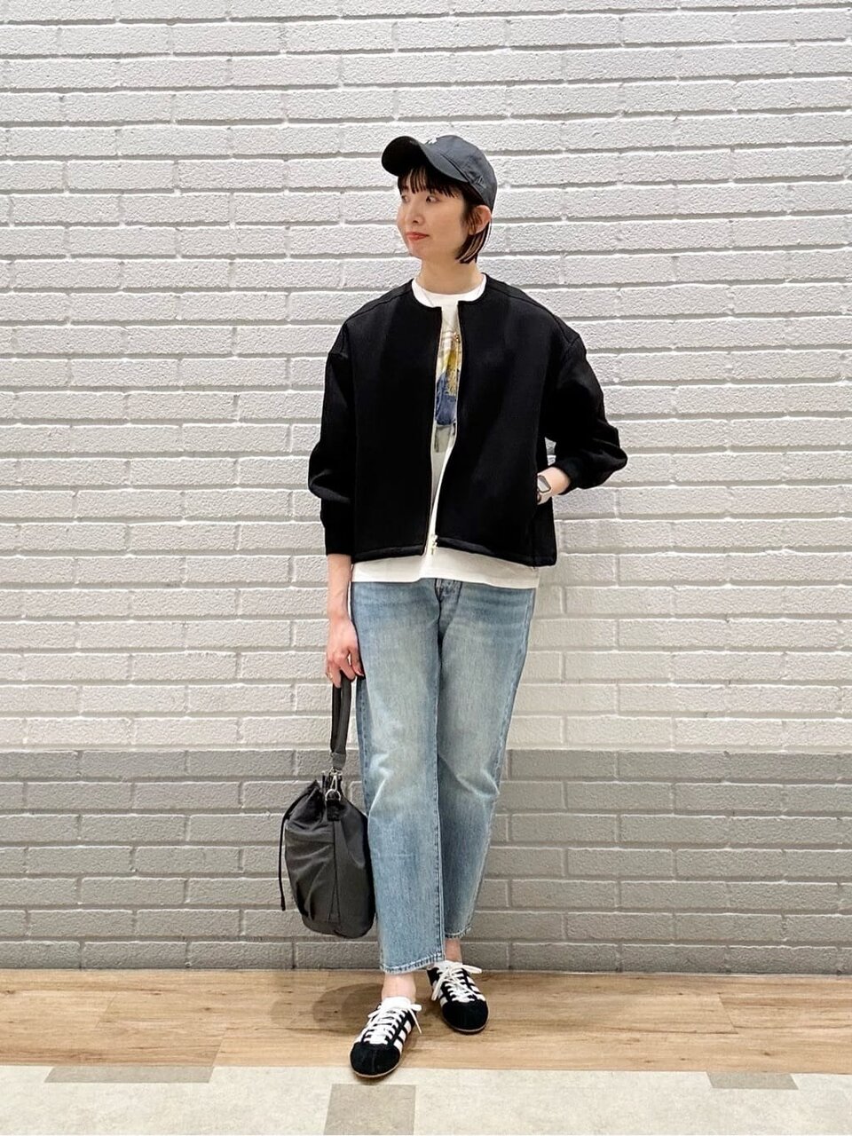 ジップブルゾン×デニムパンツを着た女性