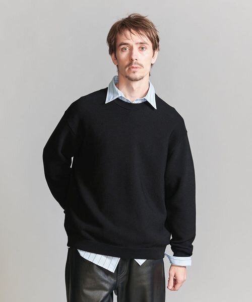 シャツにニットをレイヤードした男性