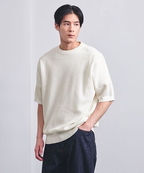 オフホワイトの半袖トップスを着た男性