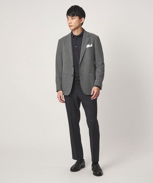 グレージャケットに濃いめのパンツをあわせた男性