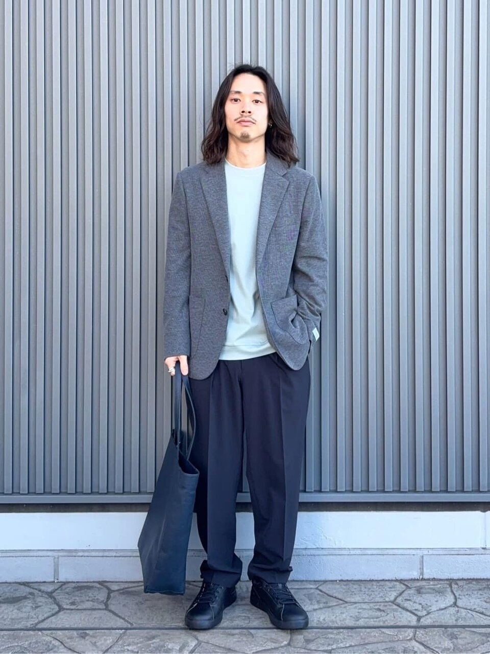 グレーのニットにジャケットをあわせたコーデ