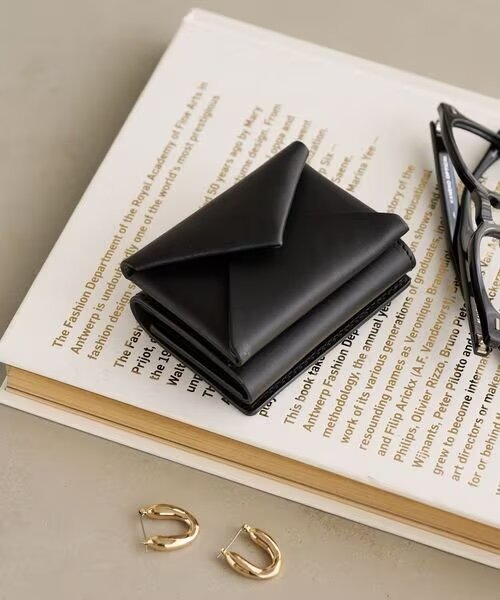 本の上に置かれた黒のミニ財布
