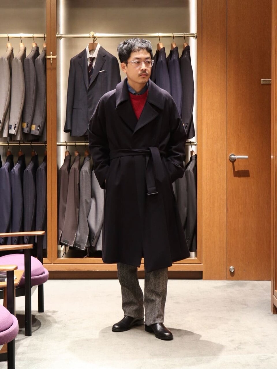 ネイビーシャツにトレンチコートを着た男性