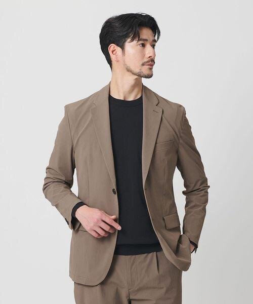 ベージュジャケットのセットアップを着た男性