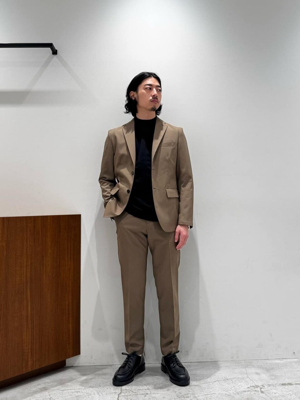 ベージュジャケットのセットアップを着た男性