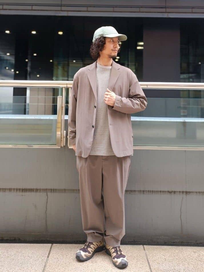 ベージュジャケットにベージュパンツをあわせた男性