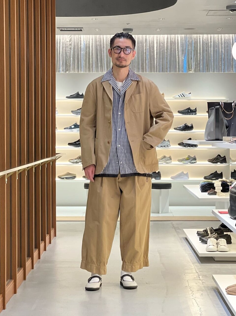 ベージュジャケットにワイドパンツをあわせた男性