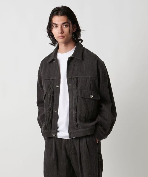 黒のデニムジャケットを着た男性