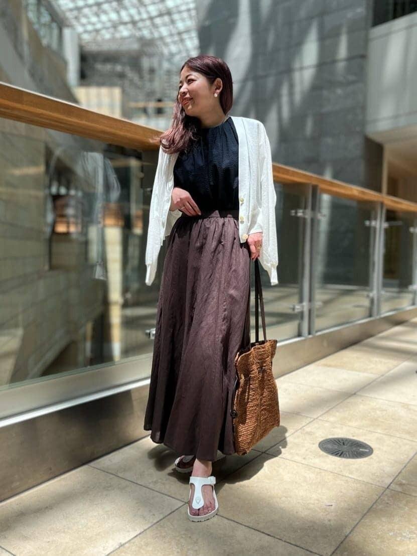 カーディガンとマーメイドスカートを着用した女性
