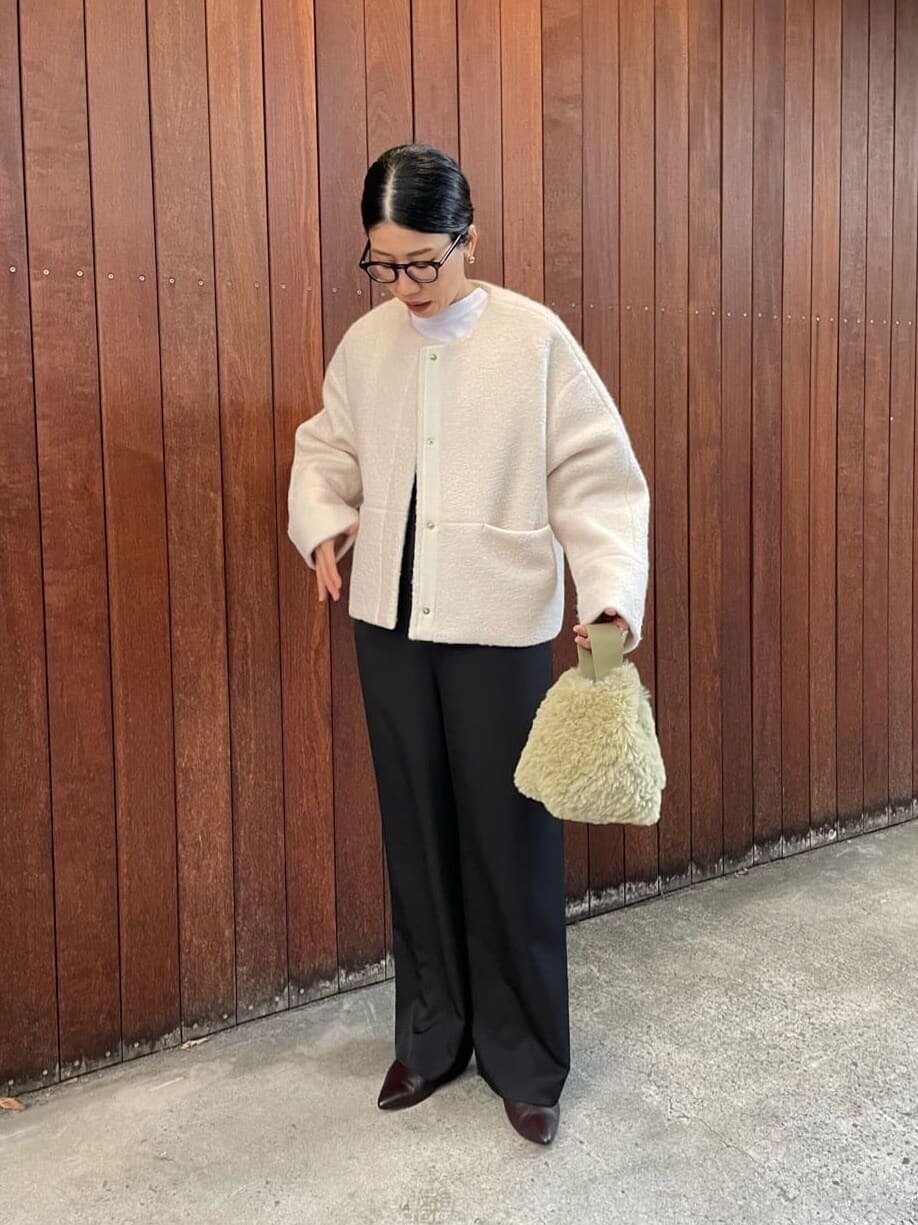 ノーカラーコートを着た女性