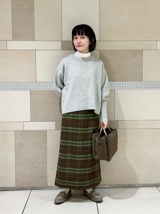 フェイクファー素材のバッグを持った女性