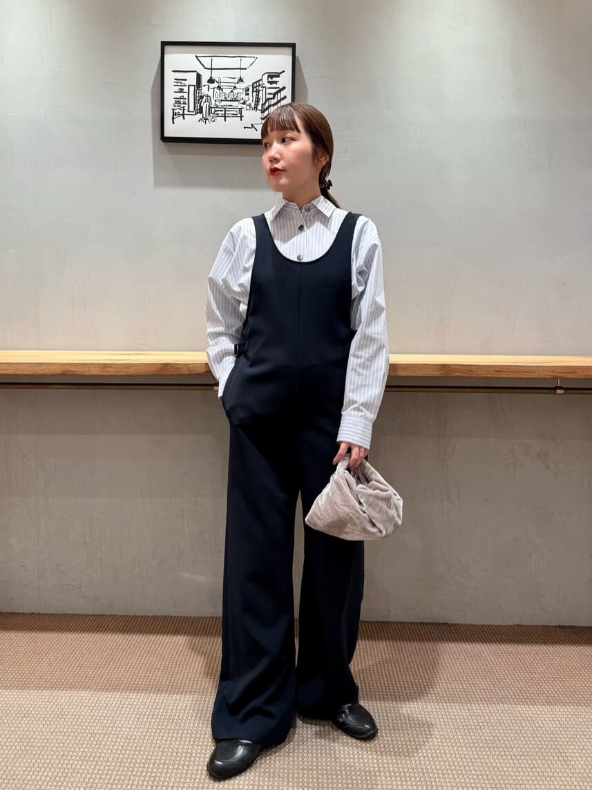 ストライプシャツとオールインワンを着た女性