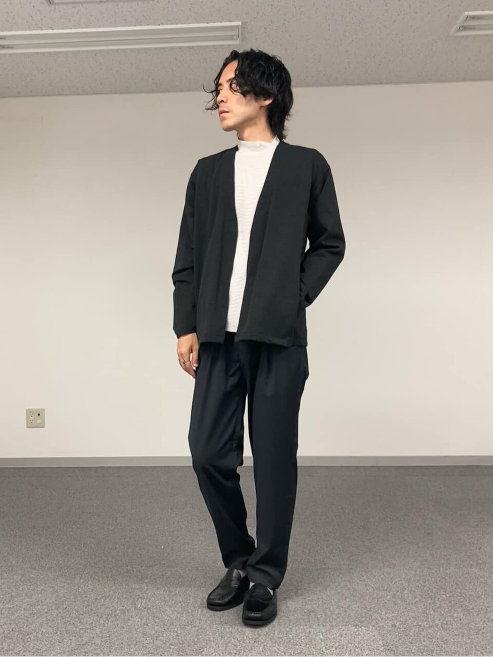 カーディガンとグレーパンツを着た男性