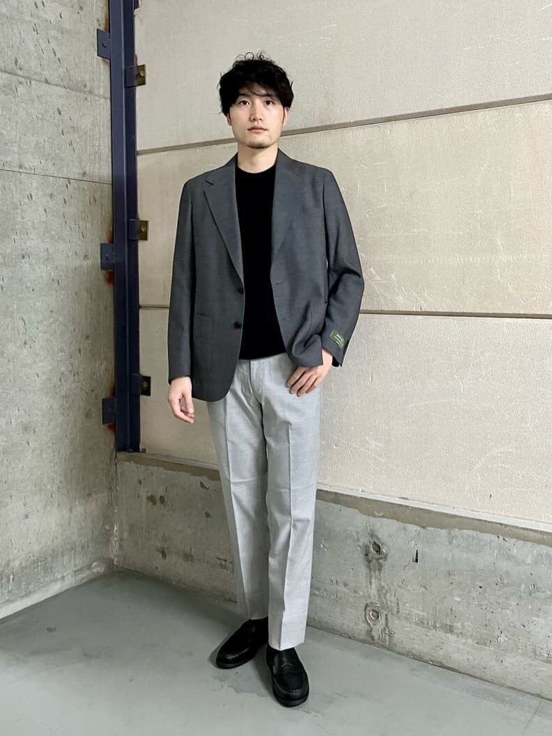 ミディアムグレーのジャケットとスラックスを着た男性