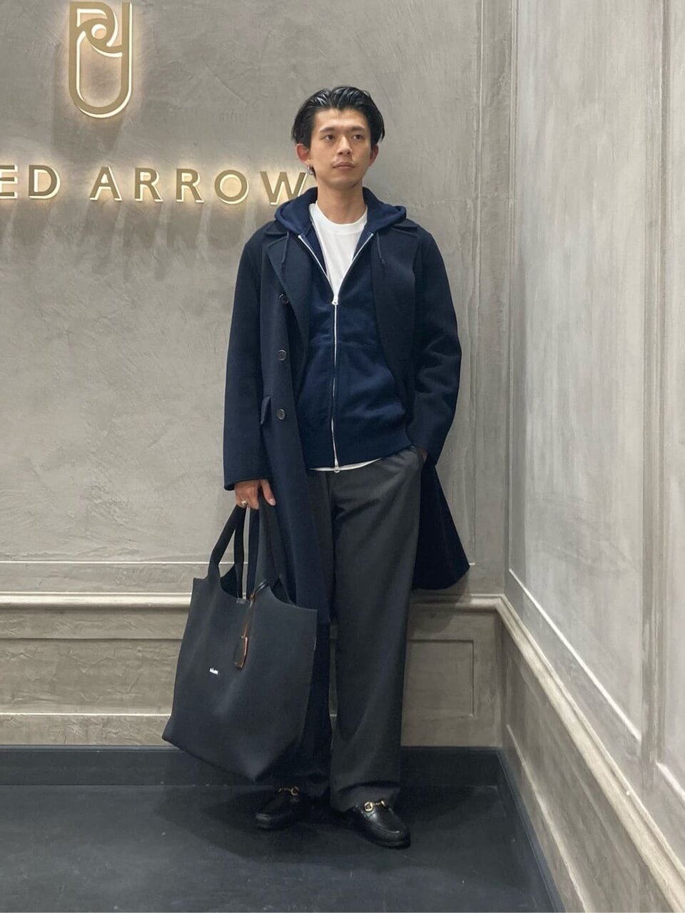 コートとグレーのパンツを着た男性