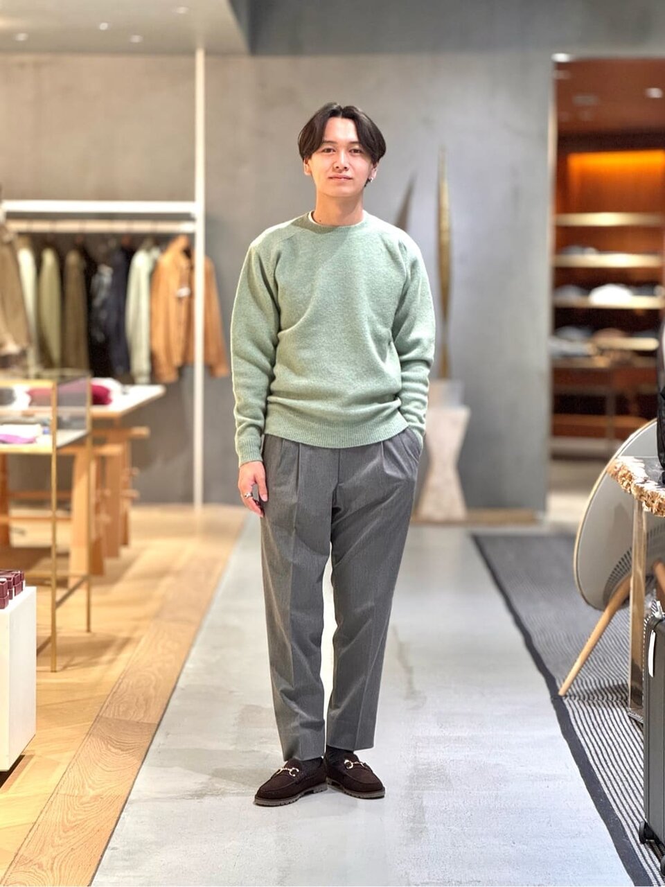 ニットとグレーのパンツを着た男性