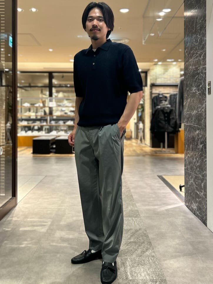 ポロシャツとグレーパンツを着た男性