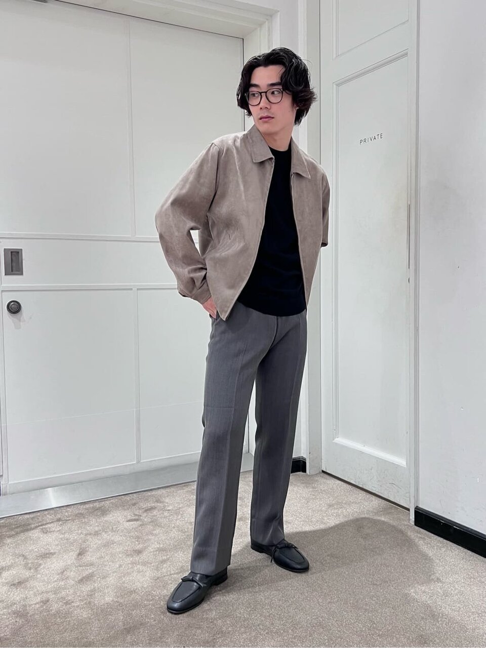 ブルゾンとグレーパンツを着た男性