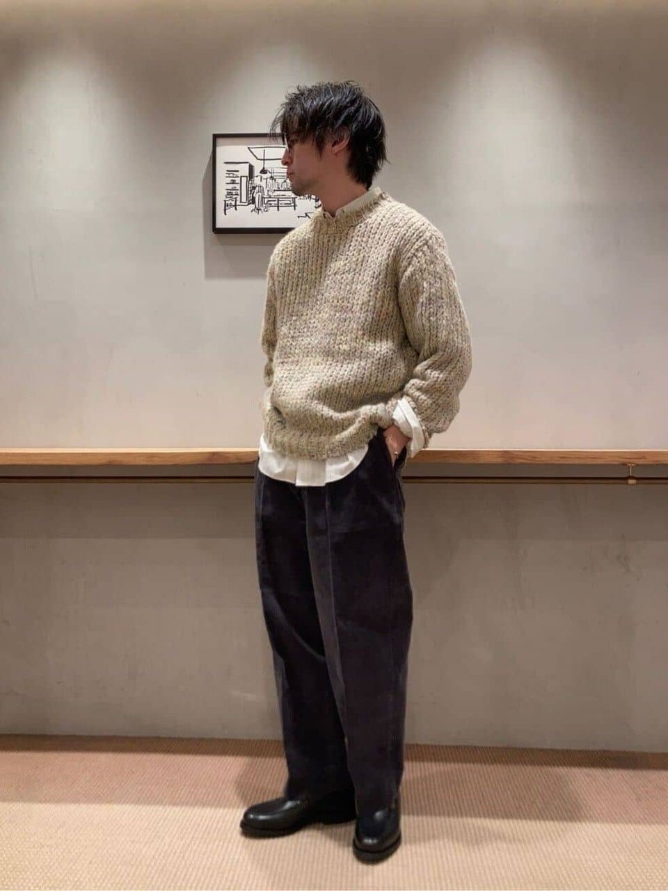 ニットとグレーのパンツを着た男性