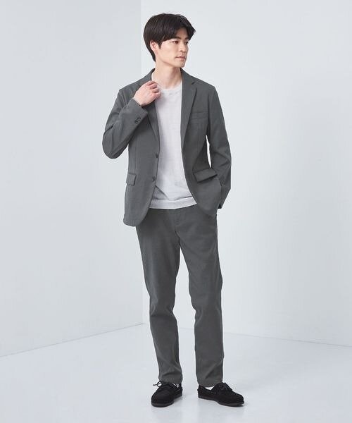 グレーのジャケットとパンツを着た男性