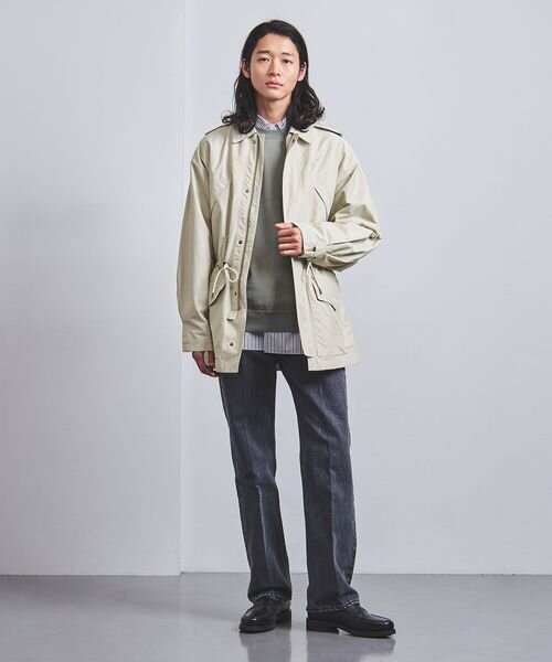 マウンテンパーカーにシャツとニットをあわせた男性