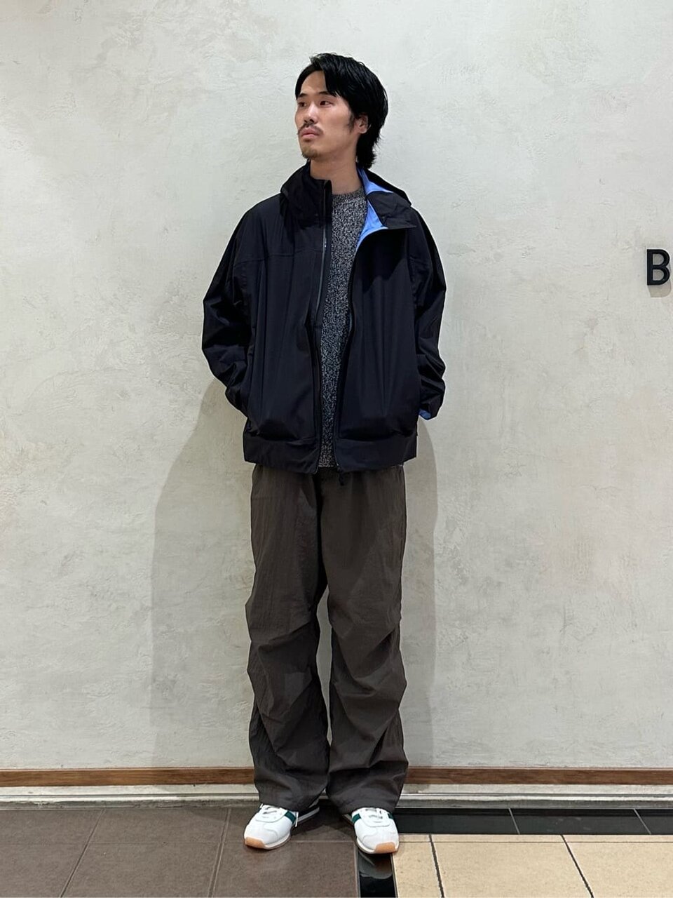 マウンテンパーカーにスニーカーをあわせた男性