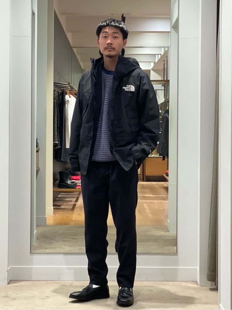 マウンテンパーカーにクルーネックニットをあわせた男性