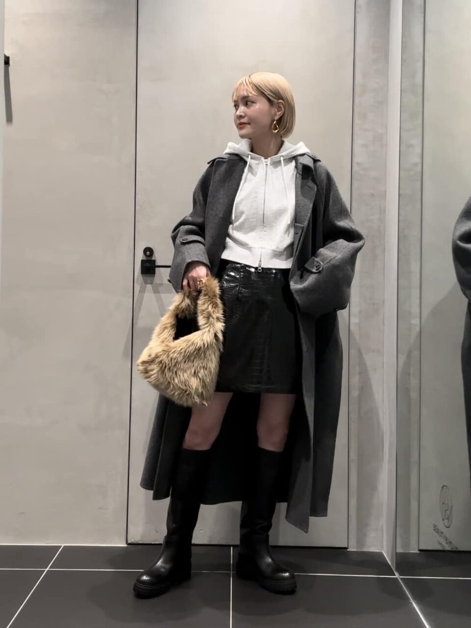 グレーのパーカーとミニスカートを着た女性