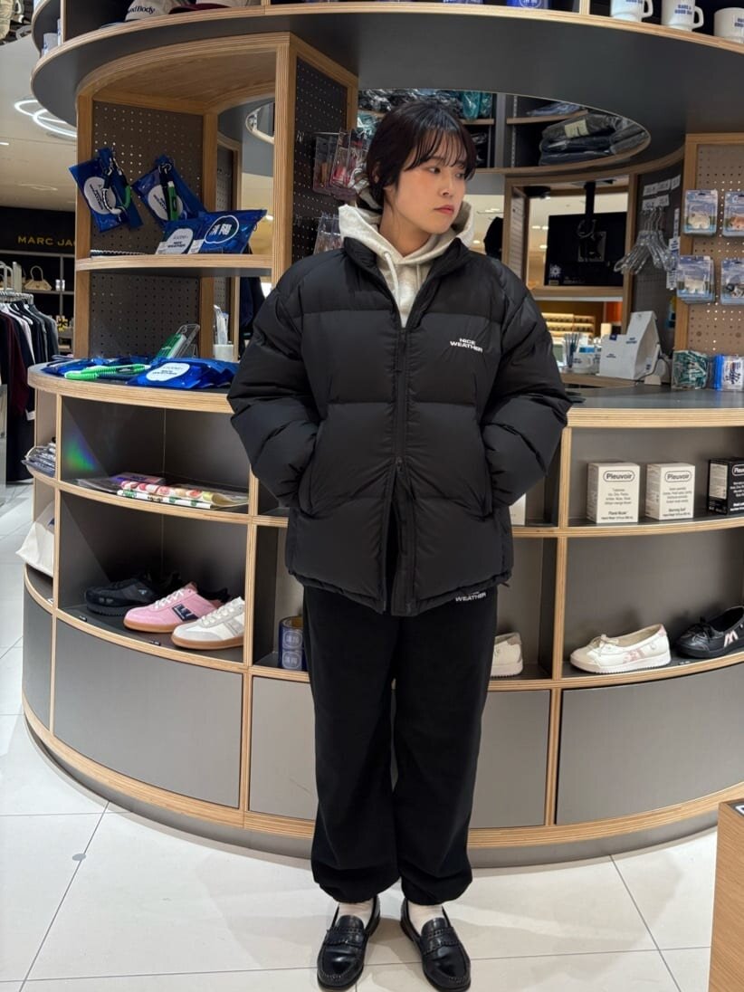 ライトグレーのパーカーとダウンジャケットを着た女性