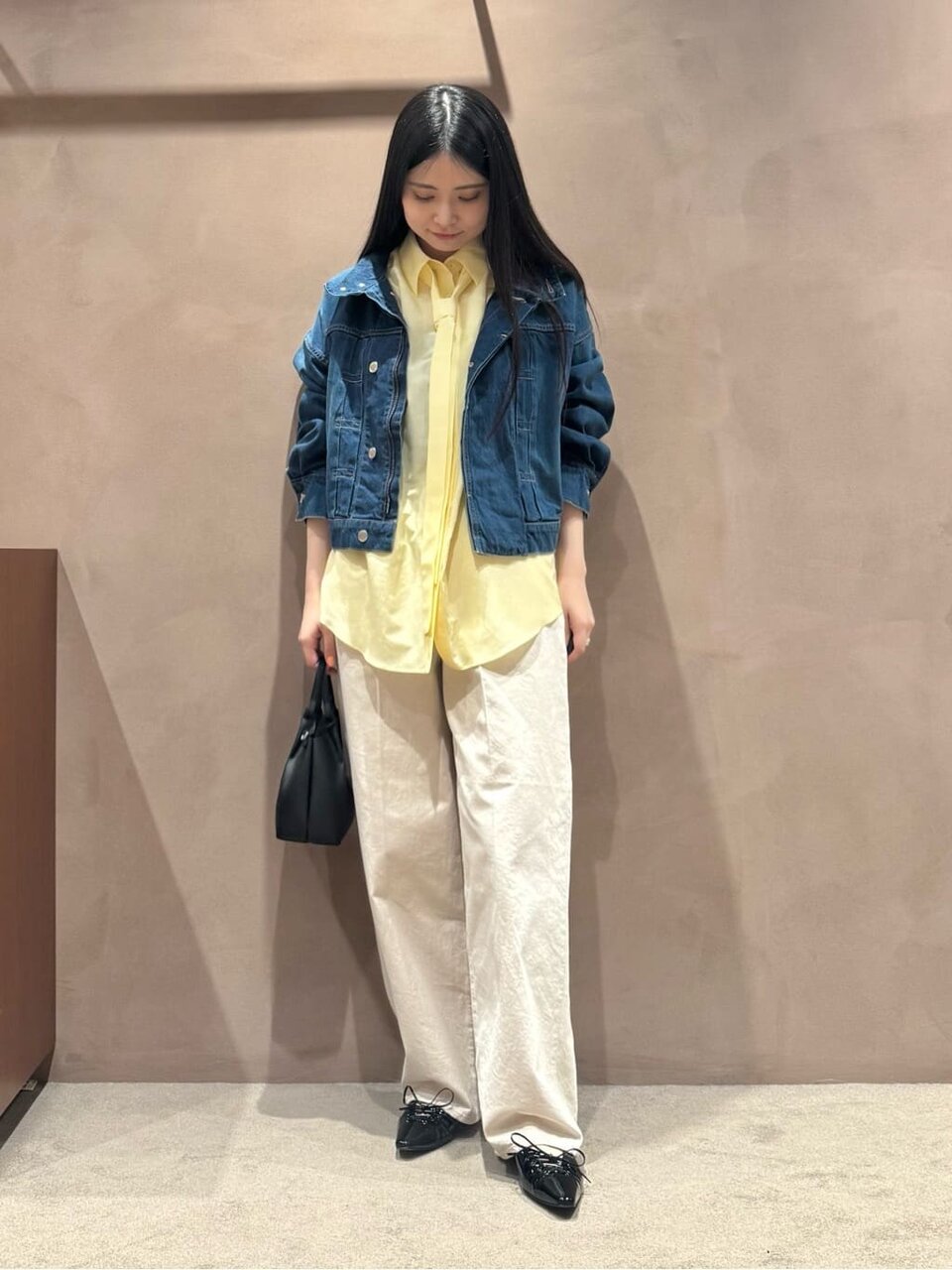 デニムジャケットとテーパードデニムを着た女性