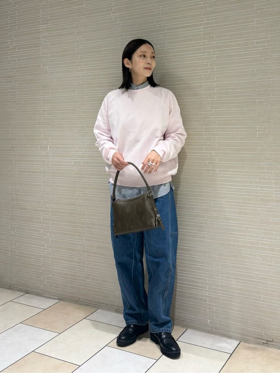 スウェットとテーパードデニムを着た女性