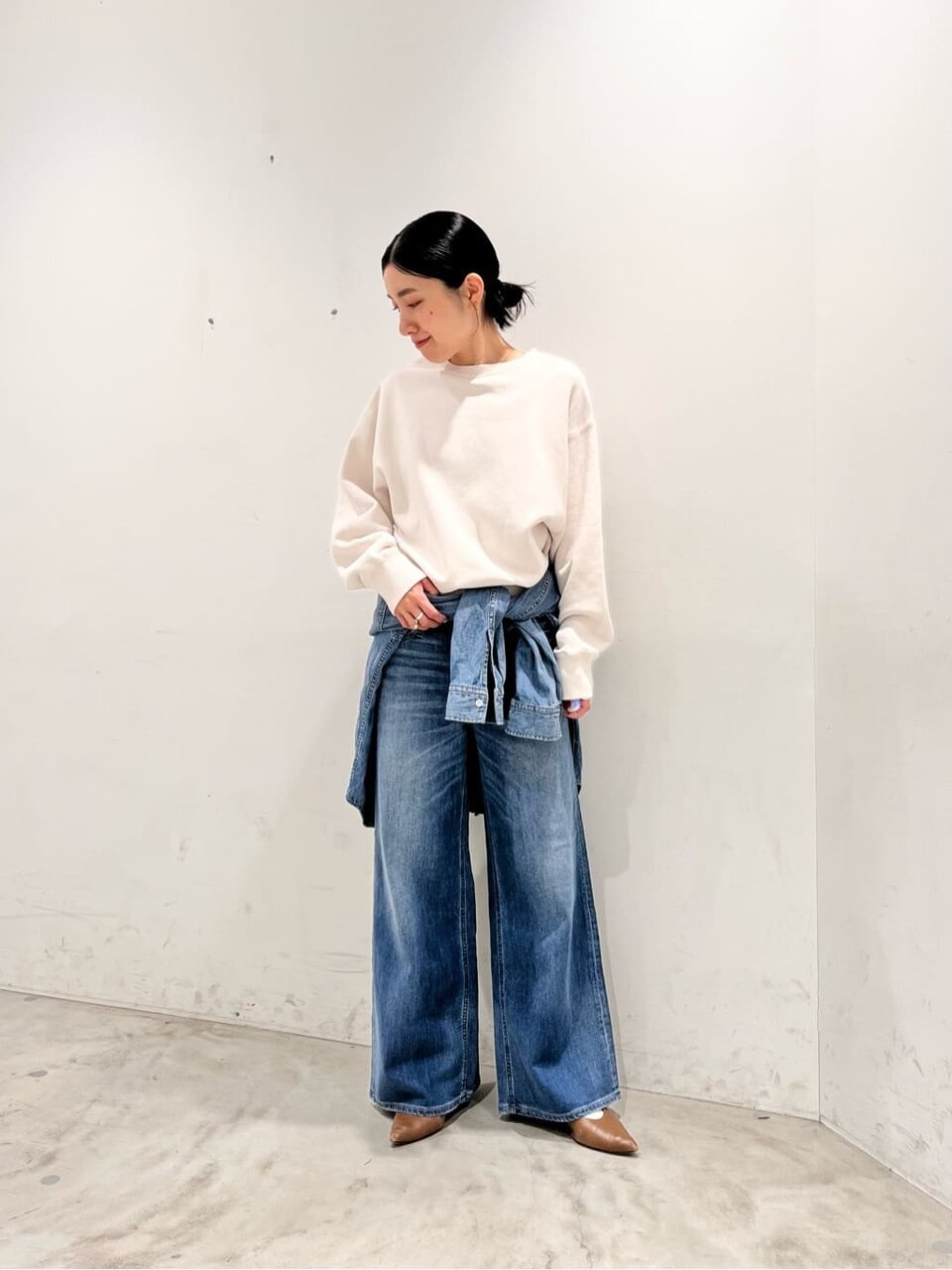 スウェットとデニムパンツを着た女性