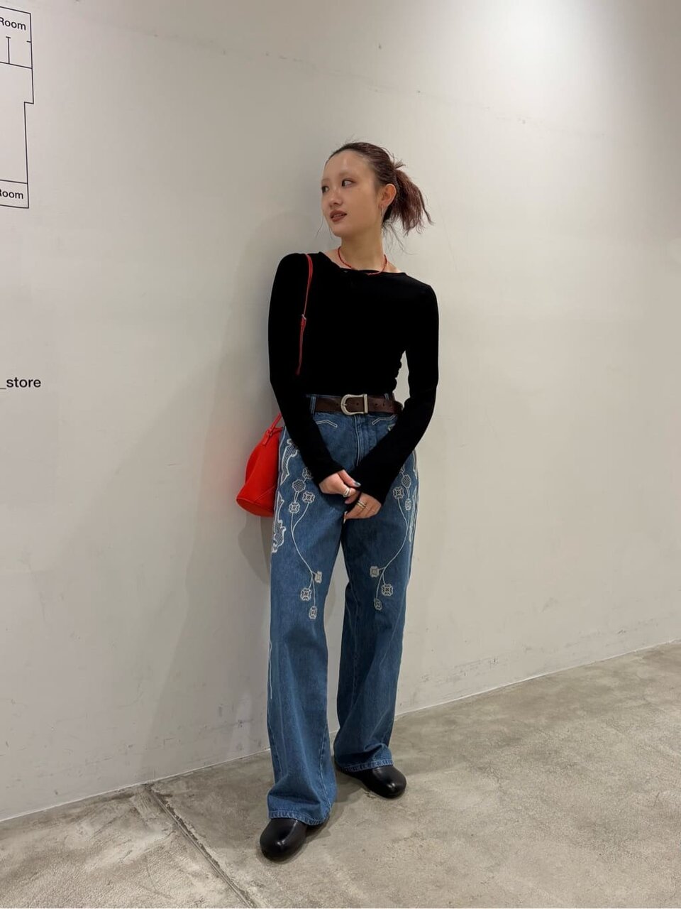 黒のトップスとデニムを着た女性