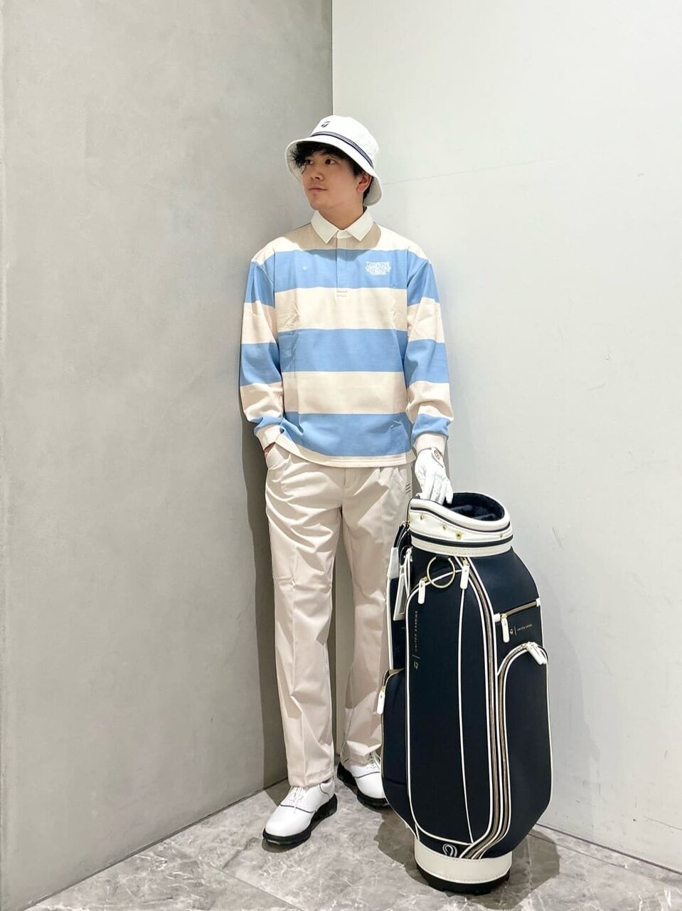 ボーダーポロシャツと白いパンツを着た男性