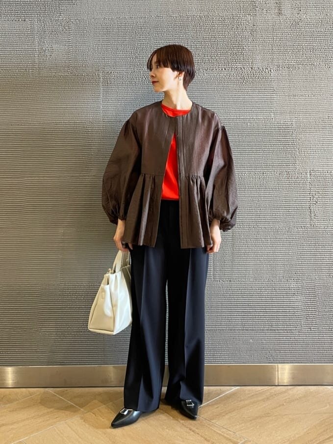 ブラウンのジャケットと赤のプルオーバーを着た女性